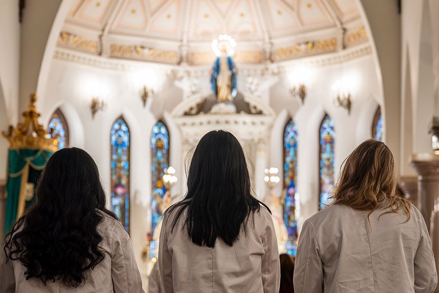 med students stand in prayer